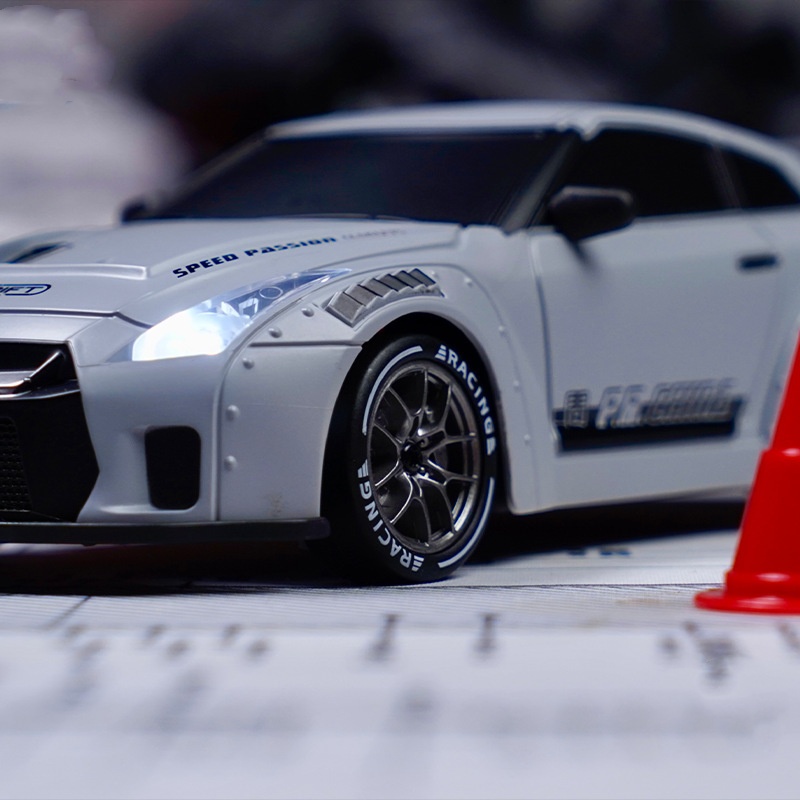 Model car with racing decals on a track with a red cone