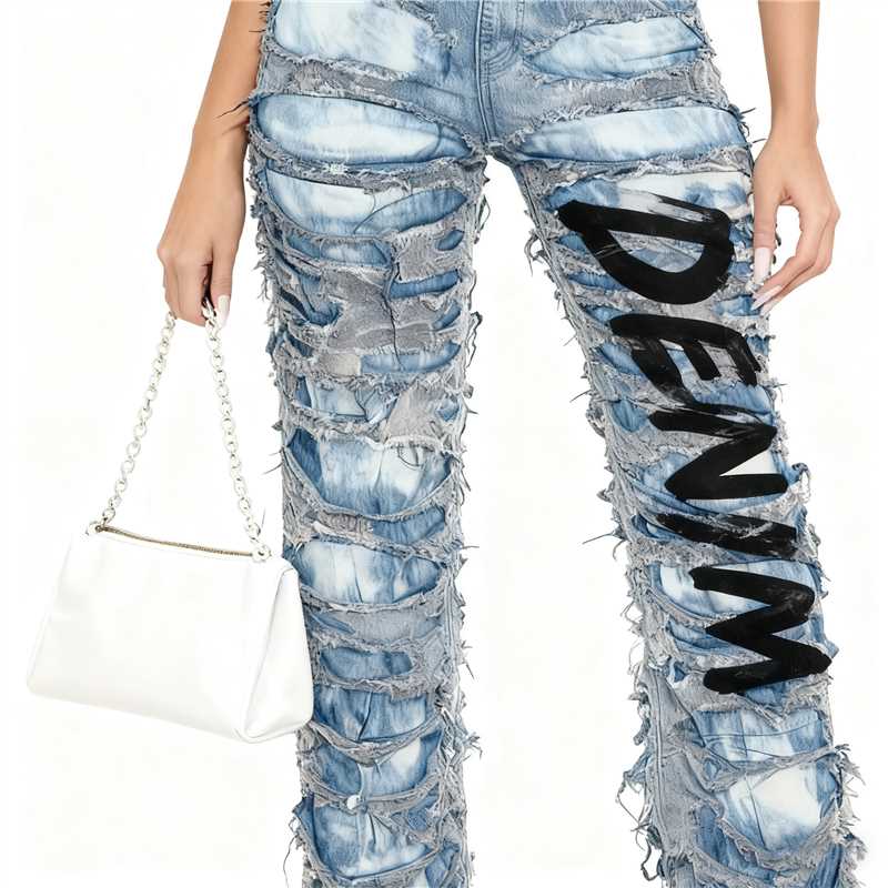 Two tone distressed wide leg jeans in light blue denim with bold black denim lettering down the leg and frayed layered cutouts.