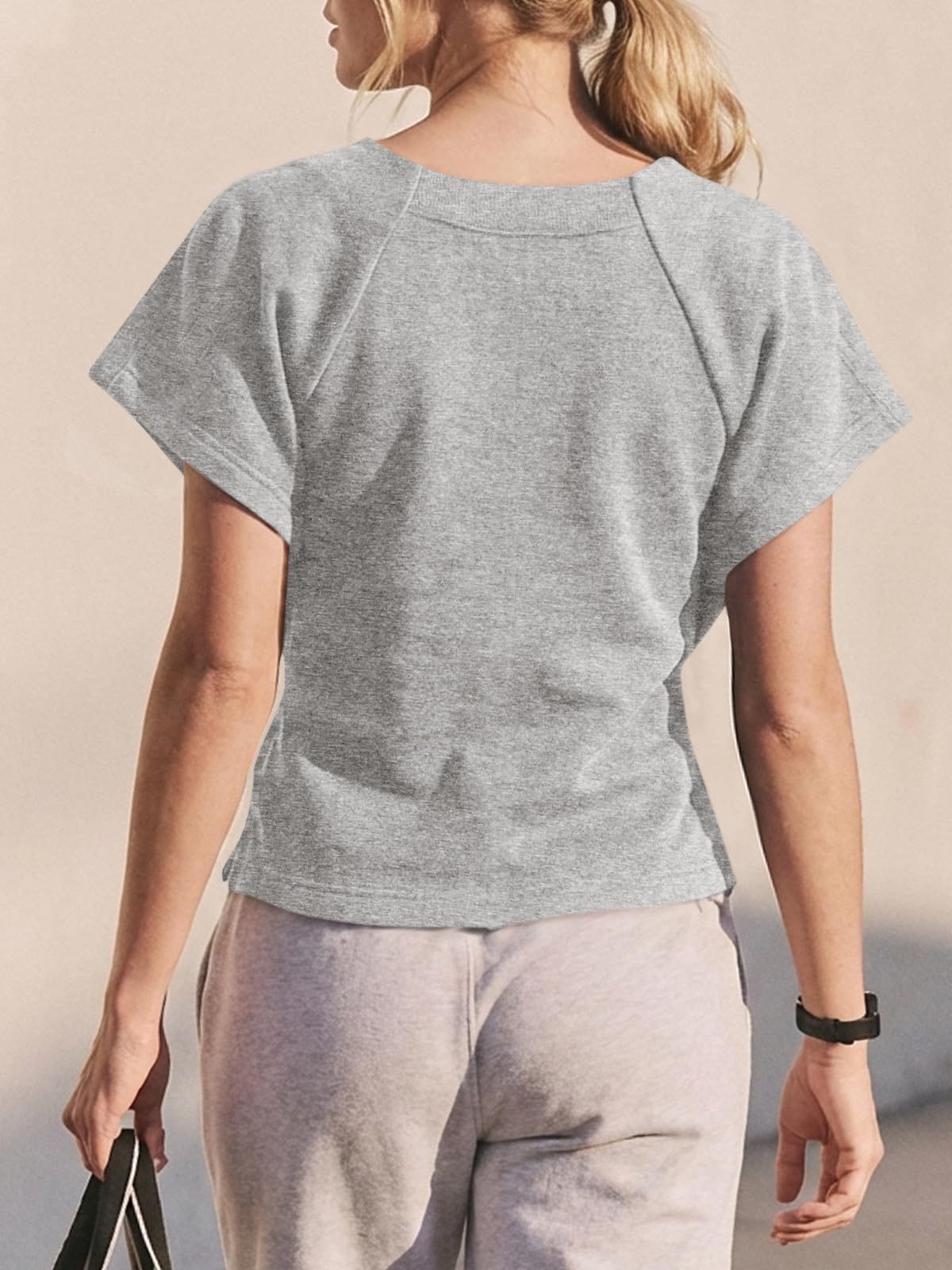 Women's loose bow-knot top in black, lifestyle photo showing relaxed casual style