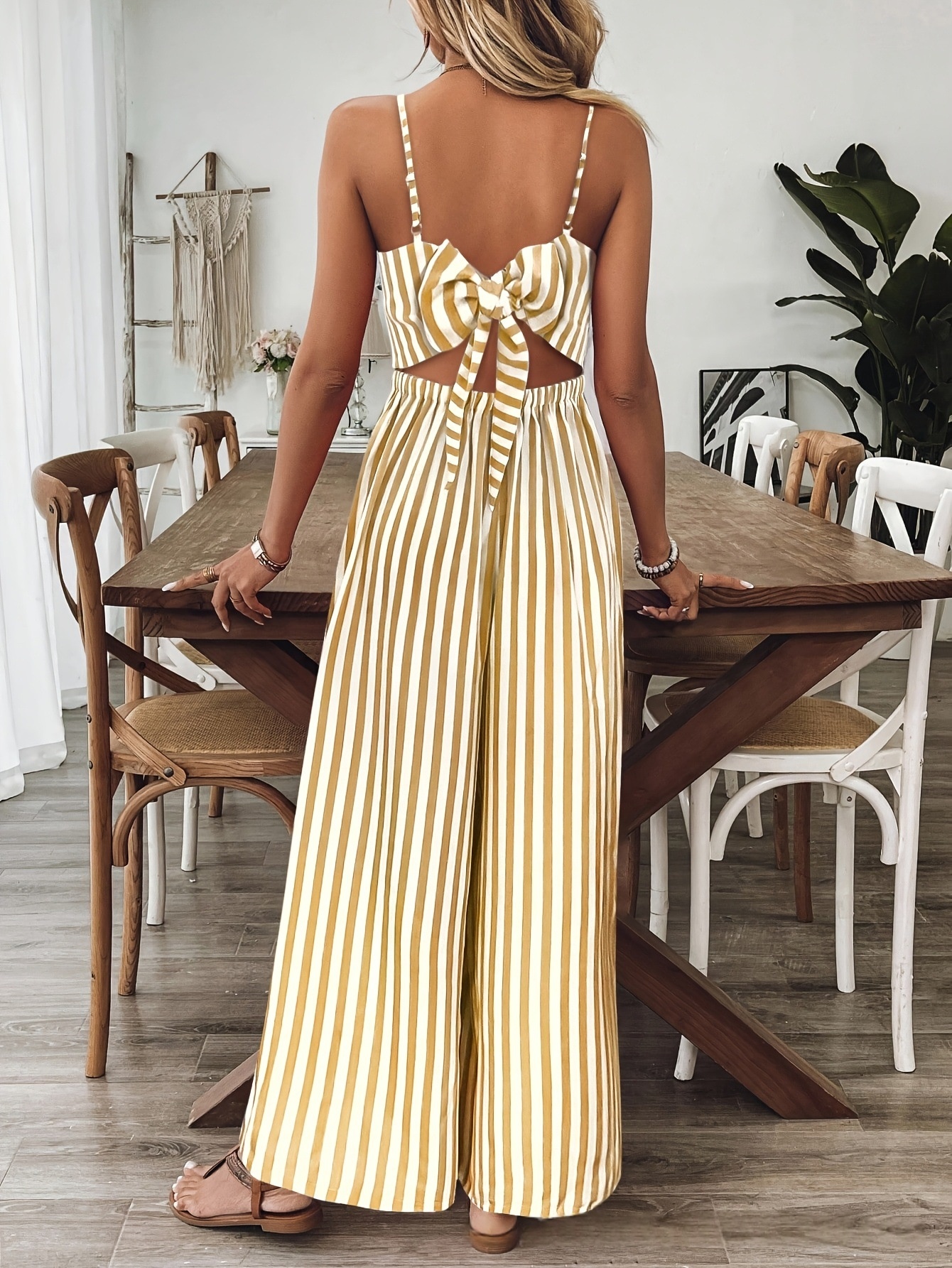 Printed backless jumpsuit in ginger yellow, model wearing outdoor lifestyle photo showing full silhouette