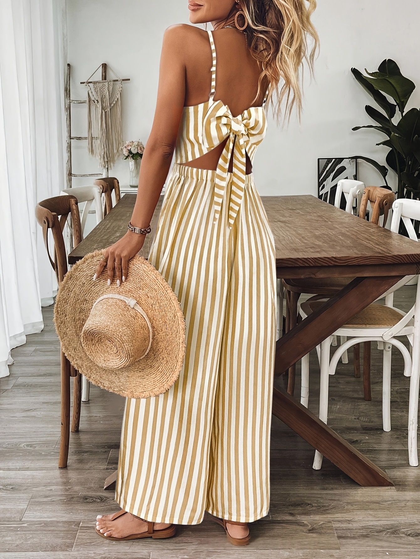 Ginger yellow sleeveless jumpsuit, model wearing back view showing backless design