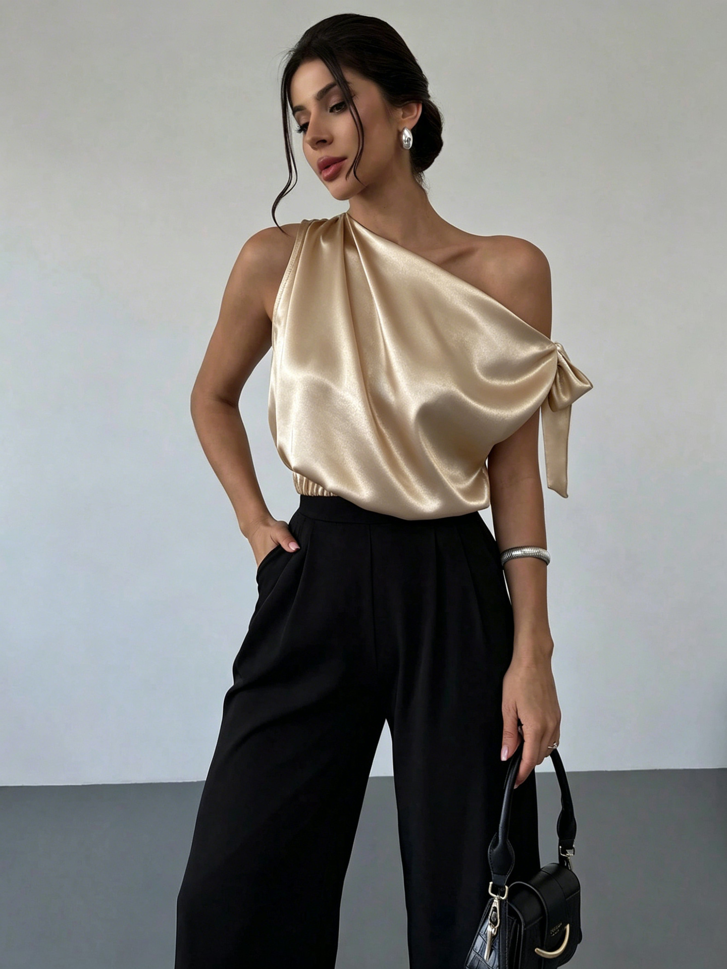 Women's satin bow blouse in Black – off-shoulder asymmetrical top, detail view of bow and asymmetrical neckline