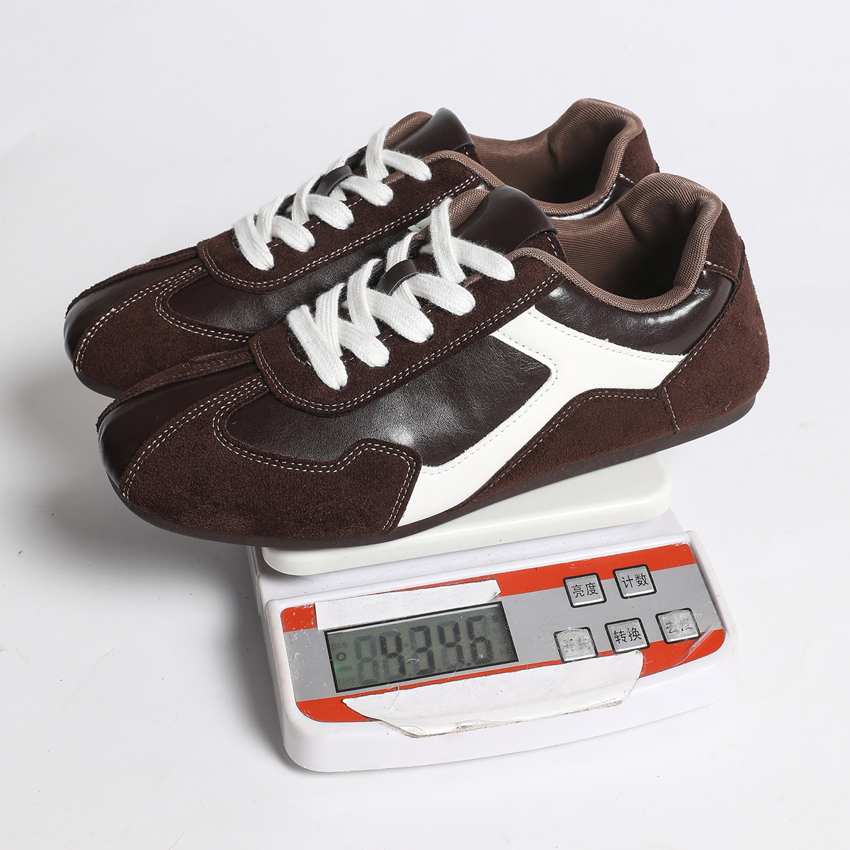 Actual dark brown trainers showing white laces, curved white side panels and contrast stitching