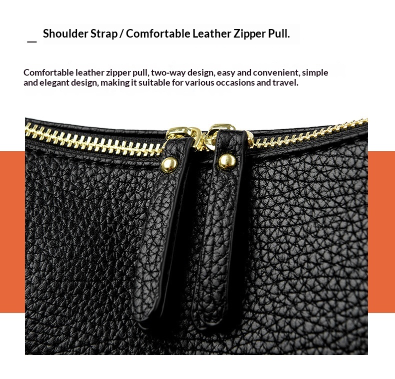 Close-up of the black bag's textured surface, gold-tone zipper and twin zip pulls