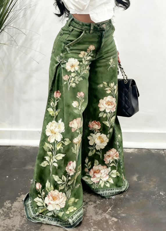 Le pantalon en denim à jambes larges vert olive présente un motif floral vibrant avec des pivoines blanches et roses, dans une conception de pantalon en denim à jambes larges à imprimé floral.